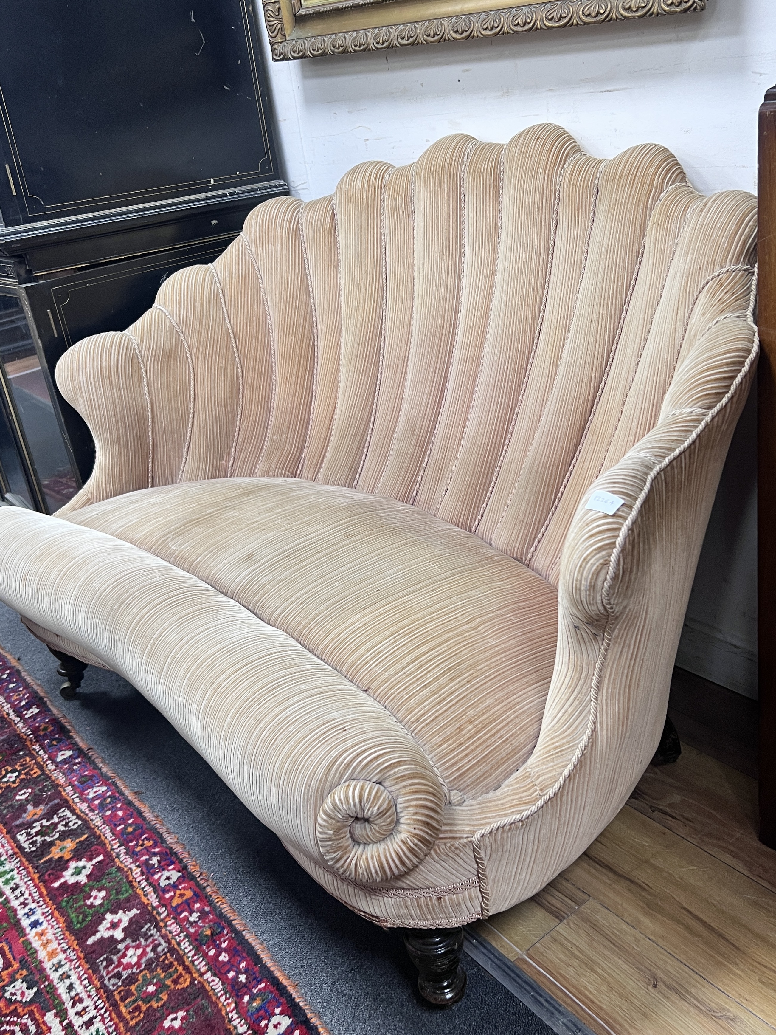 A Victorian scallop shell shaped two seater settee on turned tapered feet, length 127cm, depth 81cm, height 86cm